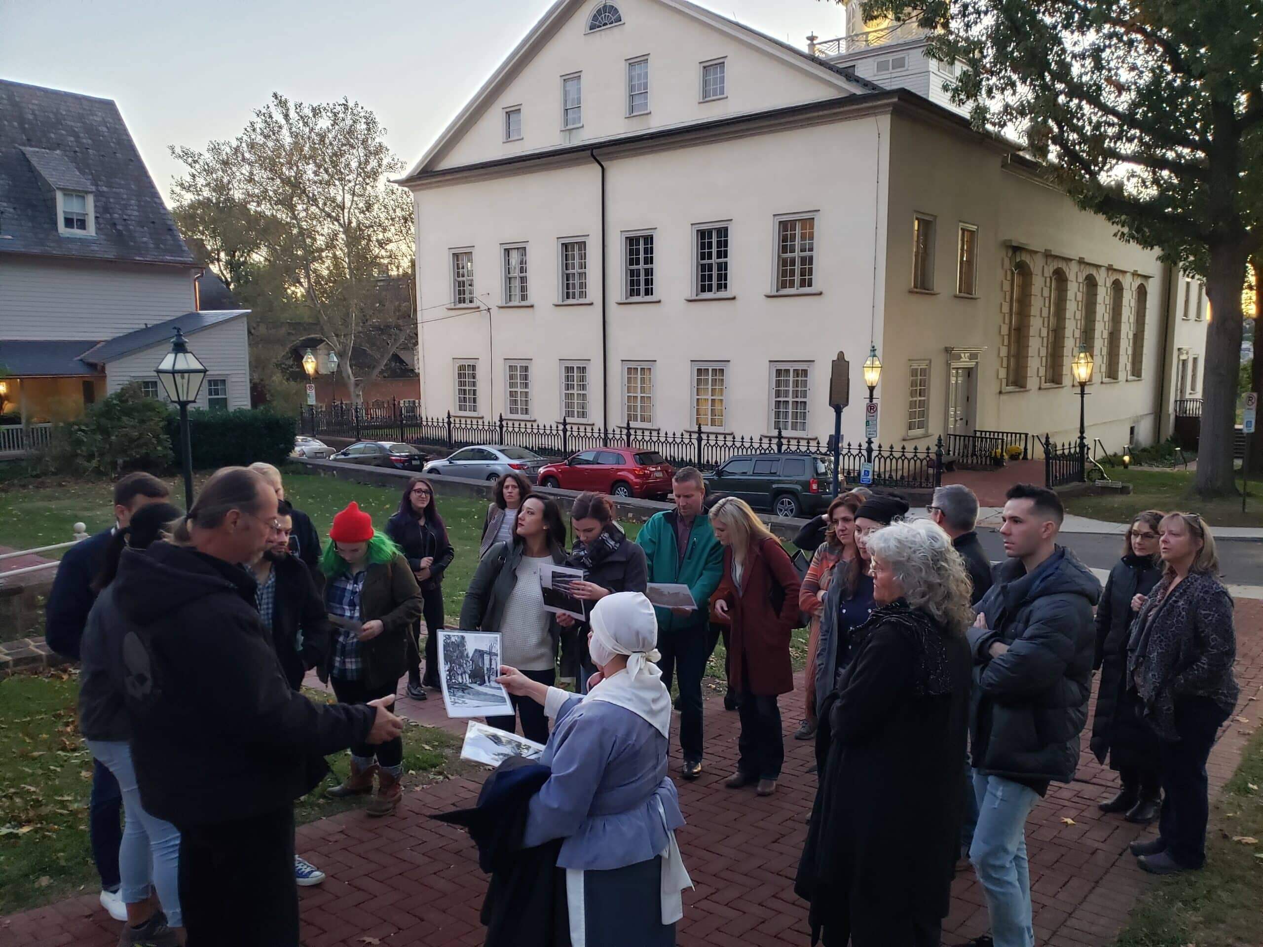 A guide in period dress with a Large group enjoying a walking tour