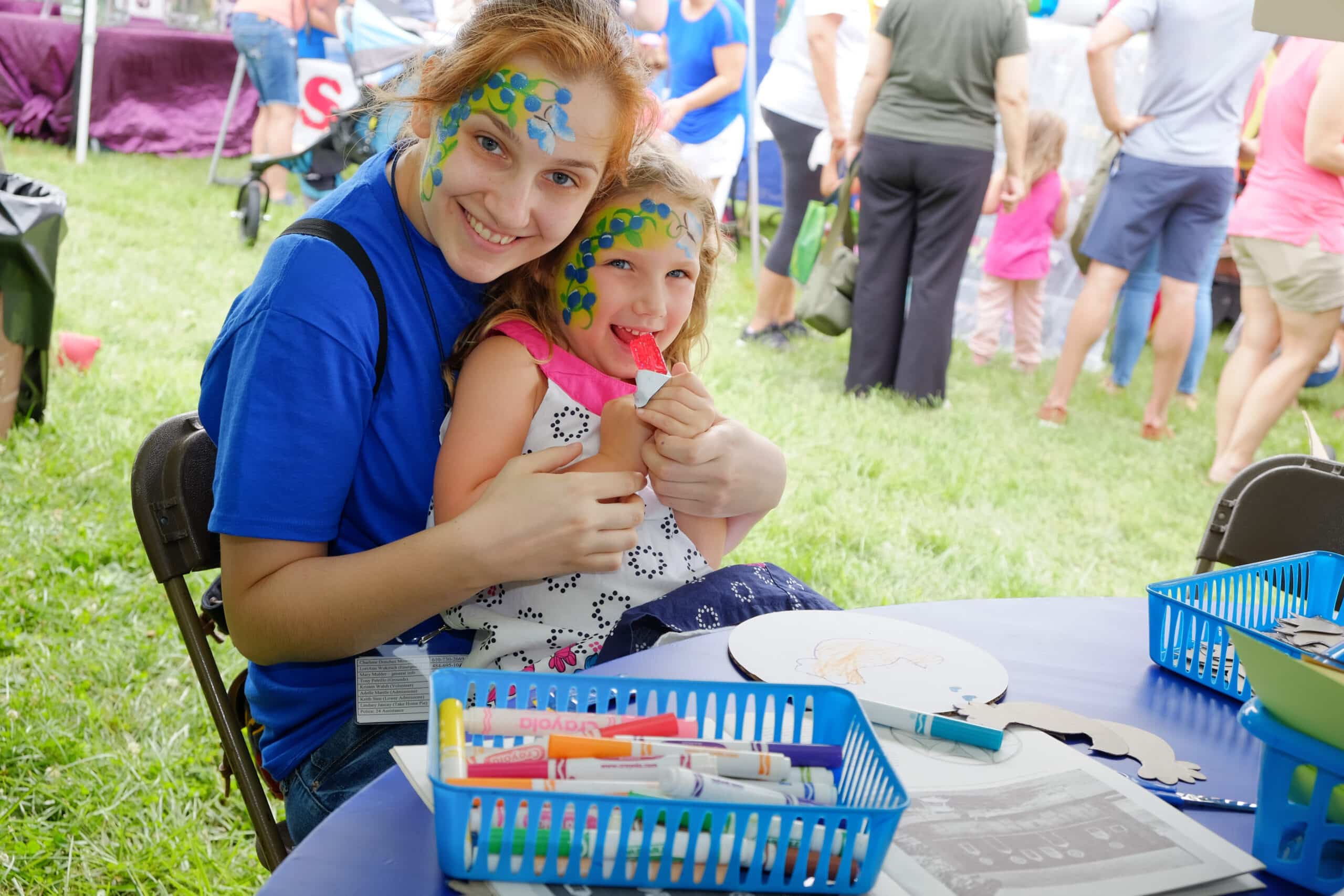 Two girls posed for a picture after getting their faces painted at the Blueberry Festival.
