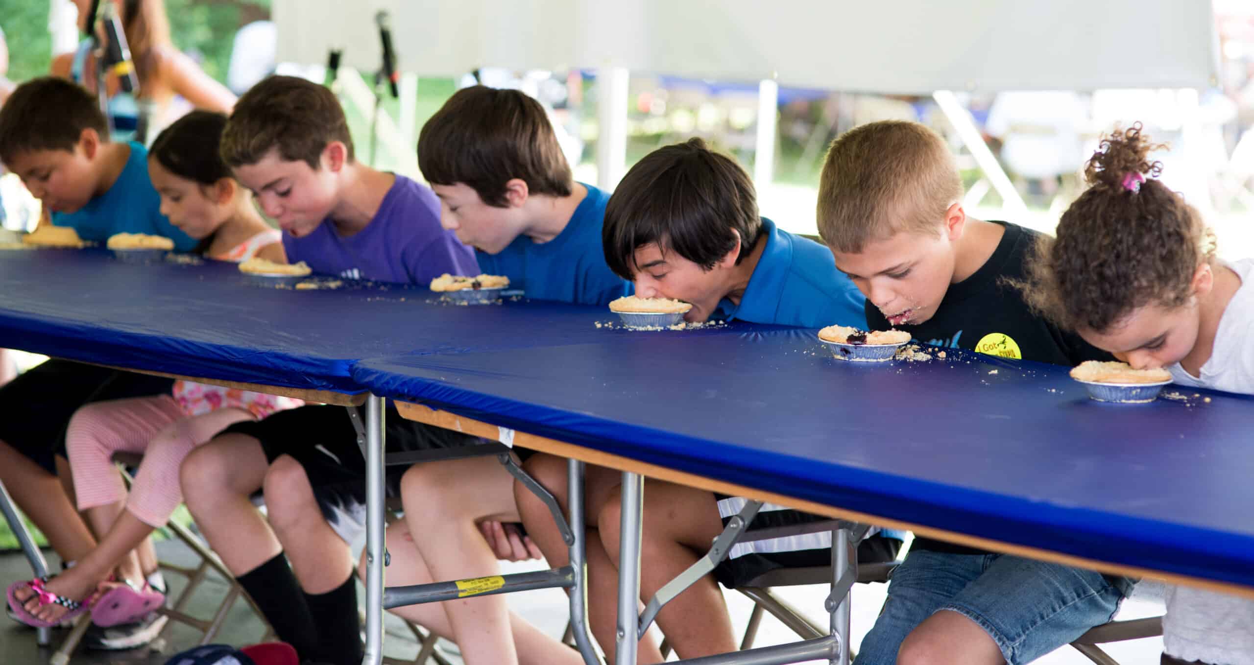 A group of boys participate in the pie eating contest at Blueberry Festival.