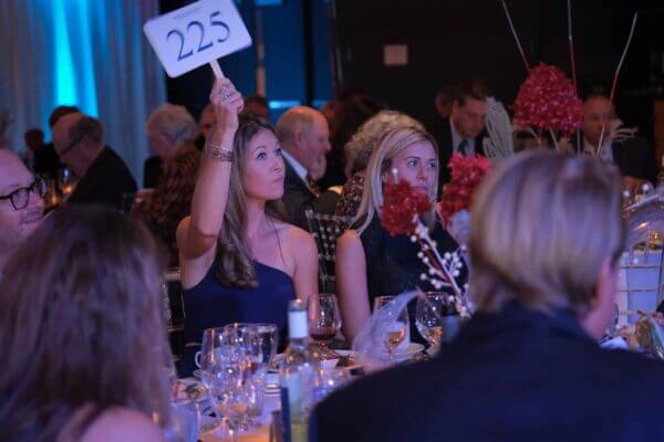 A woman bidding at the Holiday Dinner and Auction