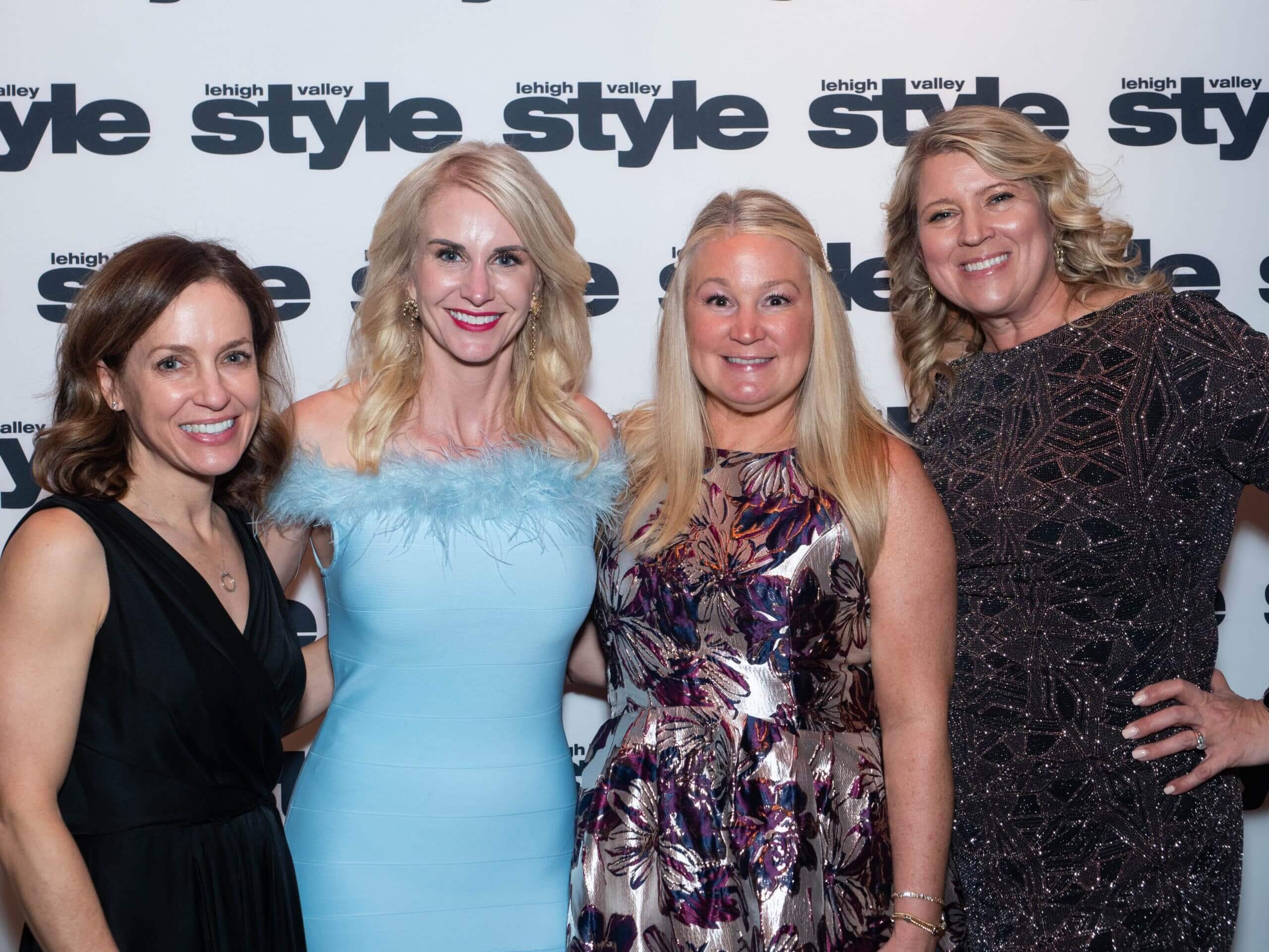 Trisha de Beer, Dawn Resch and Erica Miller in front of the Lehigh Valley Style background at the Holiday Dinner & Auction