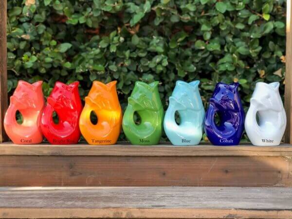 a row of gurgle pots in a rainbow of colors