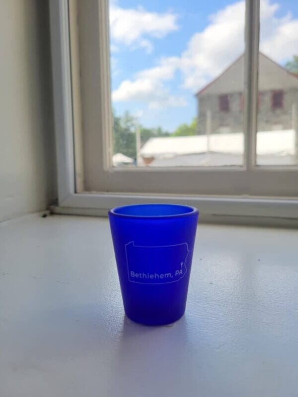 Blue shot glass with the state of Pennsylvania on it