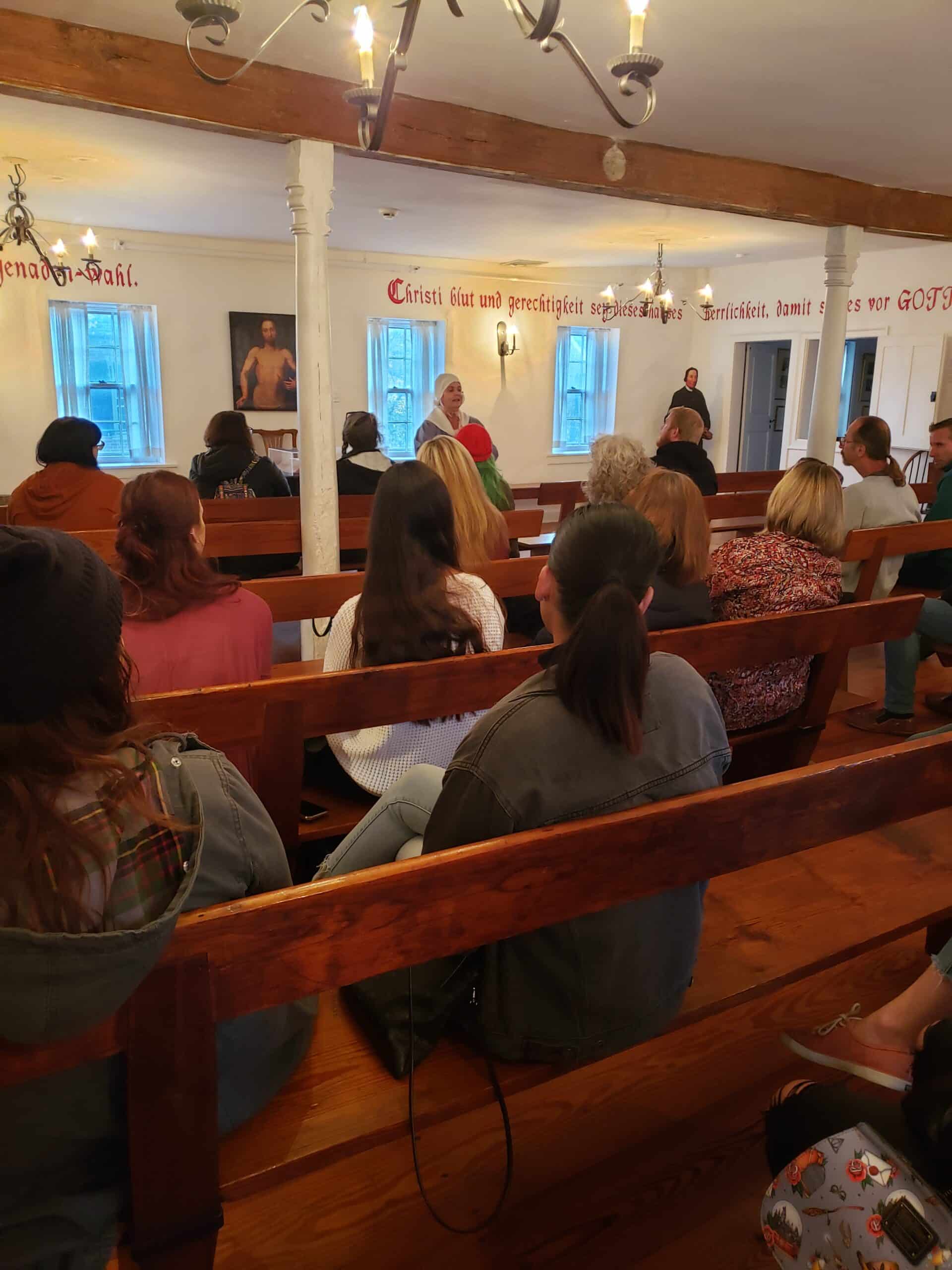 A tour group listening to their docent in the Gemeinhaus