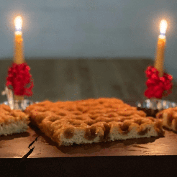 Moravian Sugar Cake sitting on a table in front of two candles