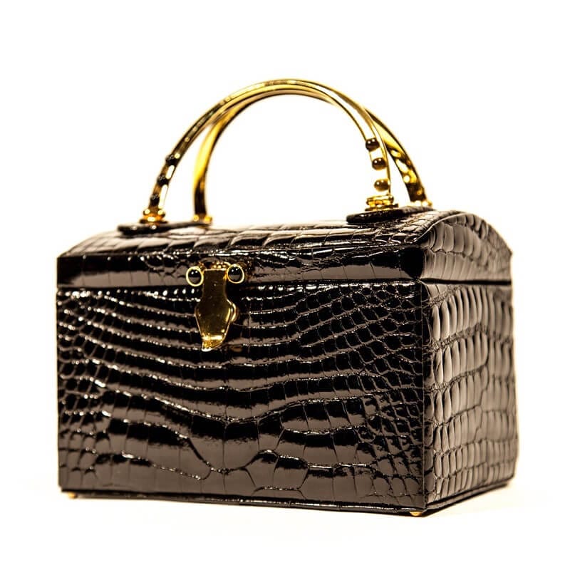 A black, snakeskin patterned box purse with golden handles