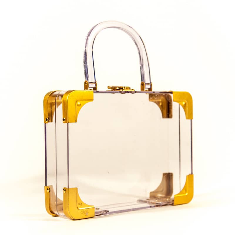 A transparent box purse with gold around the edges