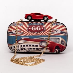 A purse with a route 66 graphic, gold handle and red car clasp