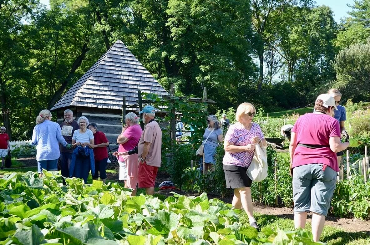 a group of people in a garden at historic burnside farm