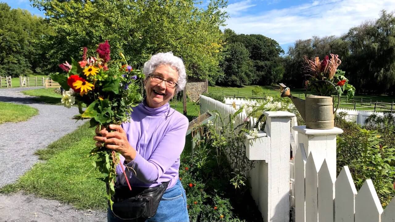 a woman holding flowers in her hand at historic burnside farm