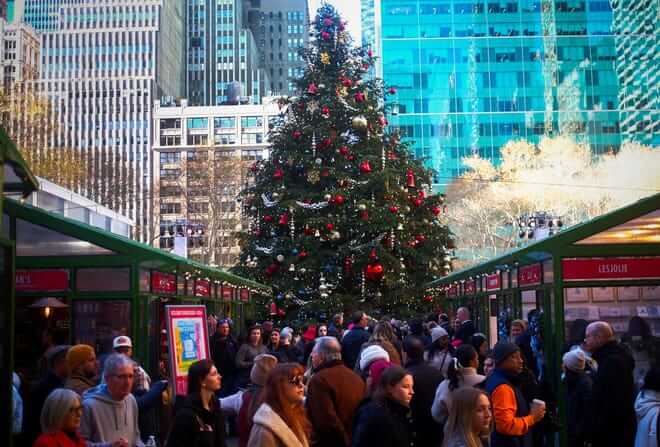 Holiday shoppers pack the seasonal Bryant Park Winter Village beneath a large Christmas tree in midtown Manhattan, in New York City, U.S., December 15, 2023.